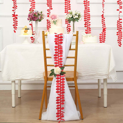 Red leaf garland decoration on a chair for a festive table setting.