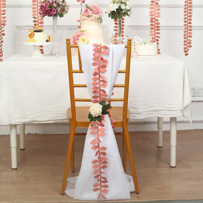 Elegant chair decoration with pink leaves and a white rose for event styling.