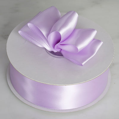 Purple satin ribbon spool with a decorative bow.