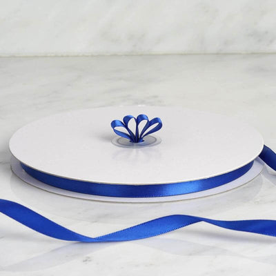 Blue satin ribbon on a white spool with decorative bow.