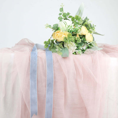 Floral bouquet with yellow roses and green accents on soft pink fabric