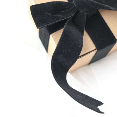 Black velvet ribbon tied around a gift box.