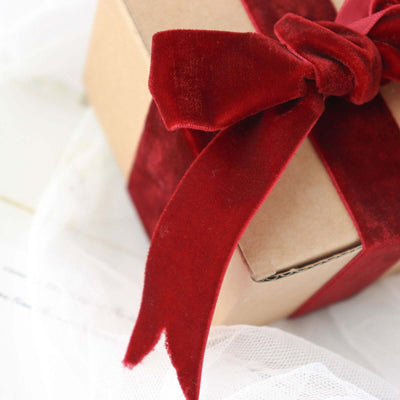 Red velvet ribbon on a gift box with brown kraft paper.