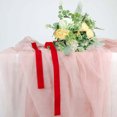Floral arrangement with yellow roses and green foliage on pink fabric