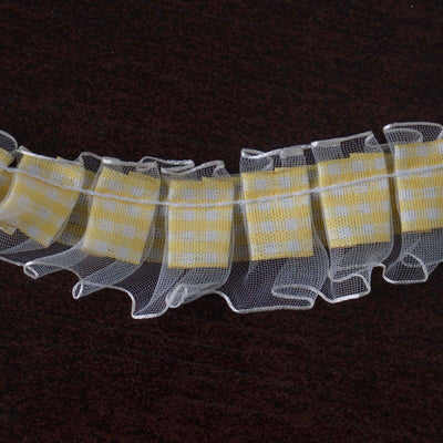 Yellow checkered ribbon with ruffled edges on a dark background.