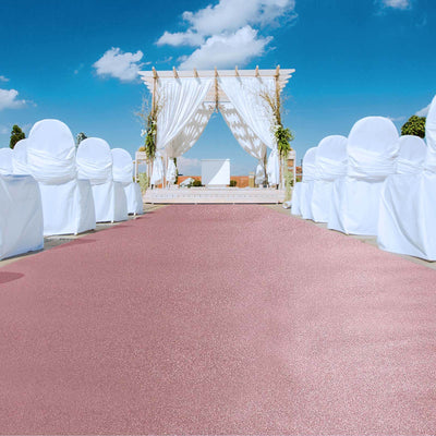 Wedding ceremony setup with white chairs and elegant backdrop under a blue sky.