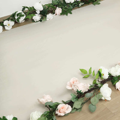 Floral garland with white and pink roses on a neutral background.