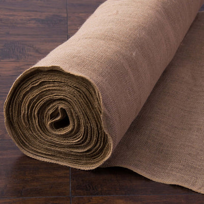 Rolled burlap fabric on a wooden surface, showcasing its texture and color.