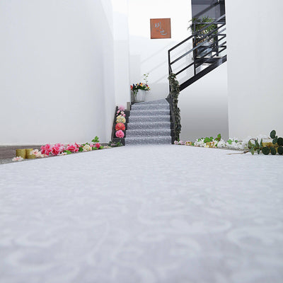 Elegant white carpet runner decorated with flowers, leading up a stylish staircase.