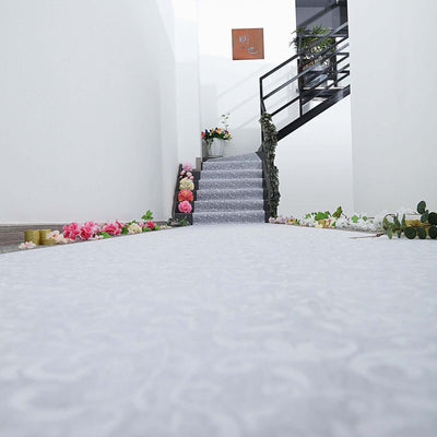 Decorative gray carpet runner with floral arrangements on either side in a hallway.