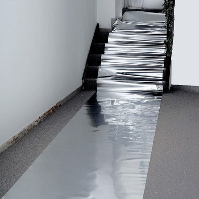 Reflective silver walkway covering on stairs and floor.