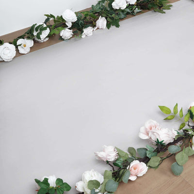 Floral arrangement with white and pink roses on a wooden surface.