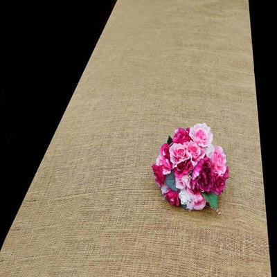 Pink and white floral bouquet on a burlap table runner.