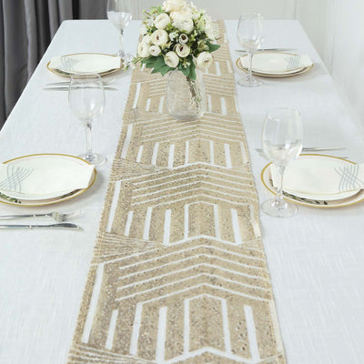 Table setting with a decorative runner, plates, glasses, and a flower centerpiece.