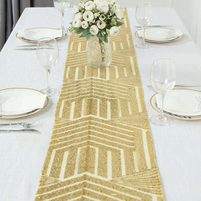 Gold geometric table runner on a dining table with plates and glasses.