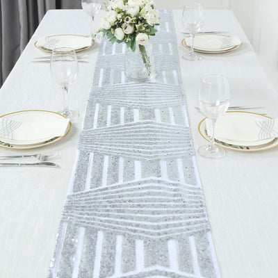 Silver geometric table runner on a dining table with elegant place settings.