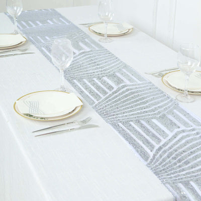 Elegant silver table runner on a white dining table setting.