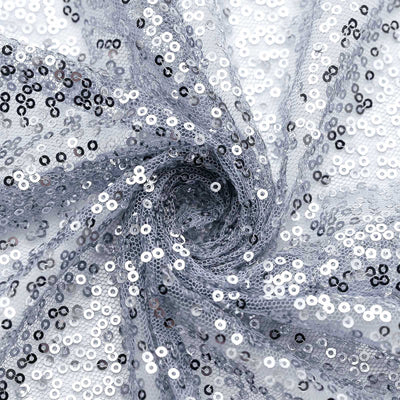 Silver sequin fabric with a shimmering texture in a spiral pattern.