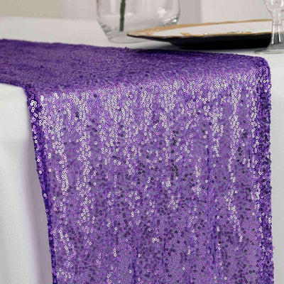 Purple sequin table runner draping elegantly over a white table.