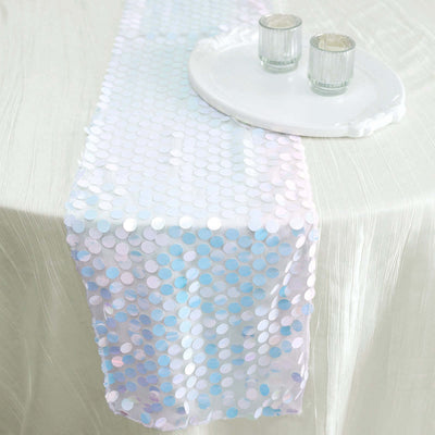 Iridescent sequin table runner on a white tablecloth with candles.