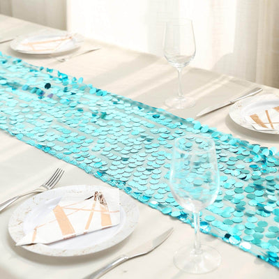 Turquoise sequin table runner on a dining table setting with glassware.