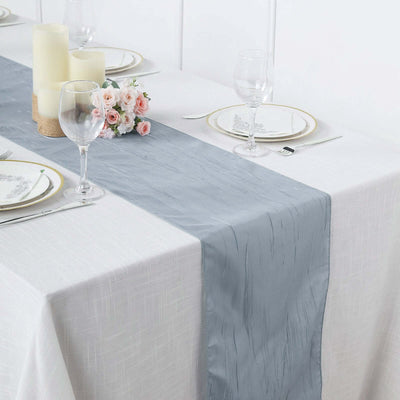 Elegant silver table runner on a dining table set with candles and flowers.
