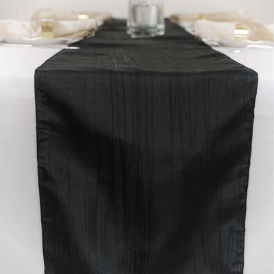 Black satin table runner on a white table setting.