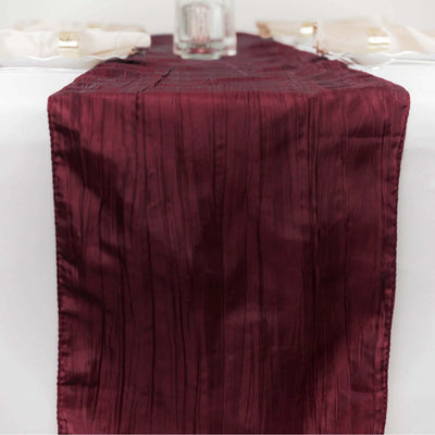 Burgundy table runner with textured design on a white table.