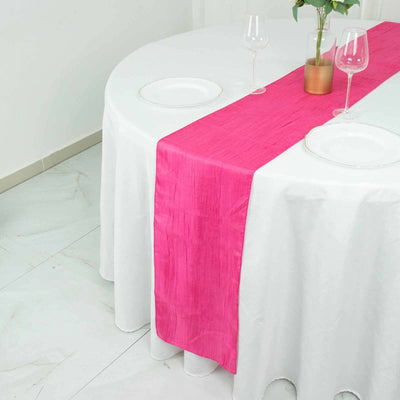 Pink table runner on a white table setting with plates and glasses.