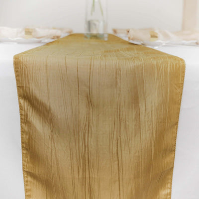 Gold table runner on a white table with a vase in the background.