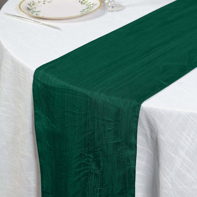 Green table runner on a white tablecloth with elegant dining setup.
