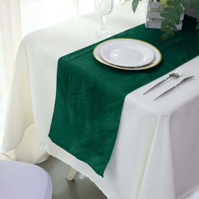 Green table runner on a white table setting with a plate and cutlery.