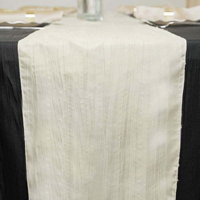 Cream textured table runner on a black table setting.