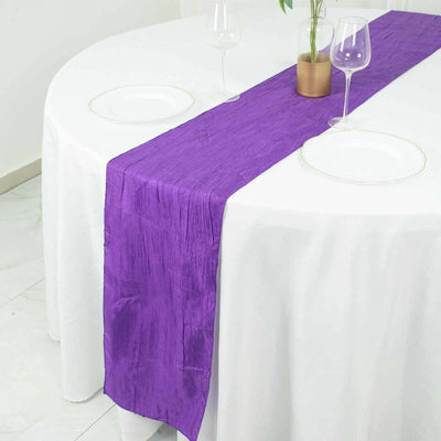 Purple table runner on a white dining table with glassware.