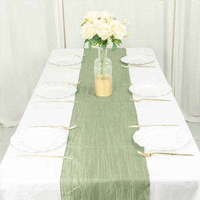 Elegant green table runner on a dining table set with white plates and gold utensils.