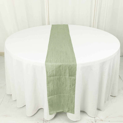 Round table with a green table runner on a white tablecloth