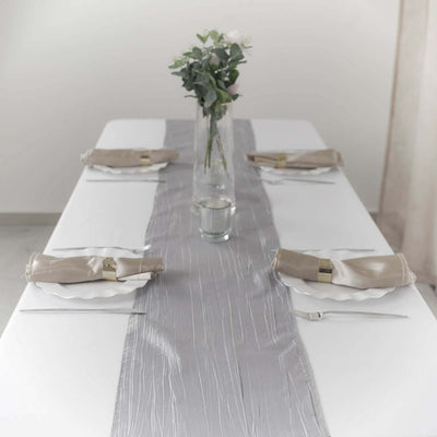 Elegant dining table set with a gray table runner and floral centerpiece.