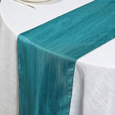 Teal satin table runner on a white tablecloth