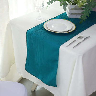 Teal table runner on a white table setting with plate and cutlery.