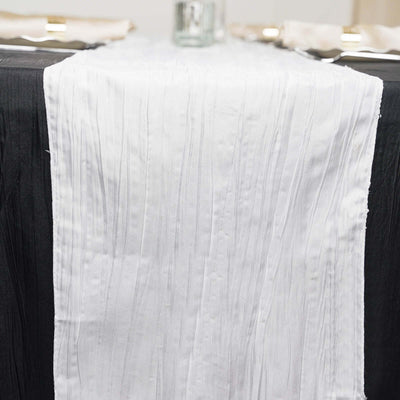 White pleated table runner on a black tablecloth