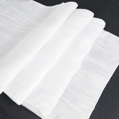 White textured fabric sheets folded neatly on a dark surface.