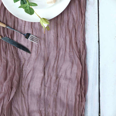 Textured mauve table runner with cutlery and a plate, styled for dining.