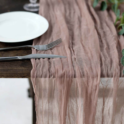Elegant dusty rose table runner on a rustic wooden table setting.