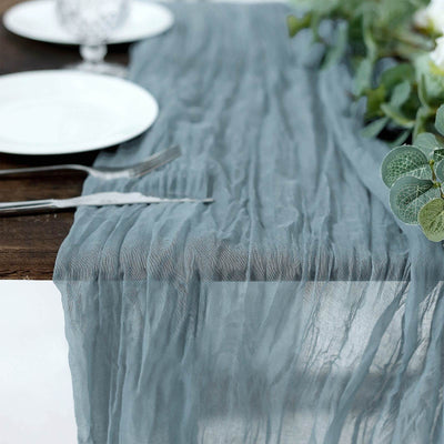 Textured blue table runner draped elegantly over a wooden table setting.