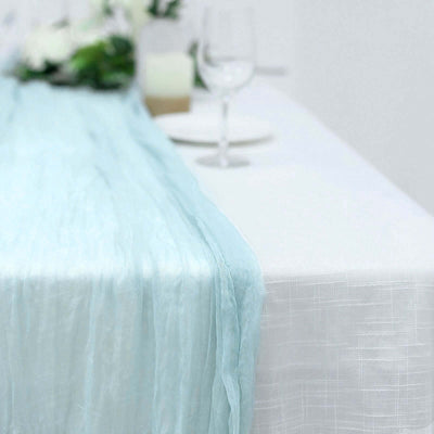 Light blue sheer table runner on a white tablecloth.