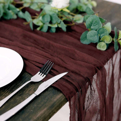 Burgundy table runner with fork and knife on a rustic wooden table