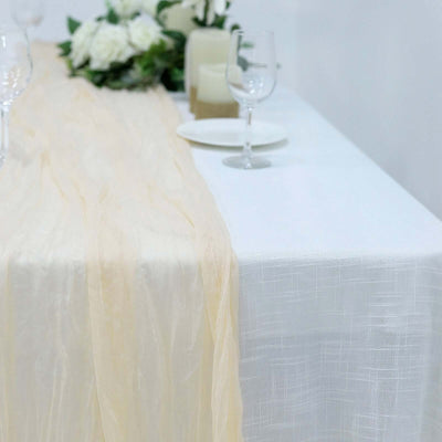 Elegant table setting with soft beige runner and floral centerpiece.
