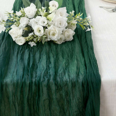 Green table runner with white rose bouquet for elegant table setting.