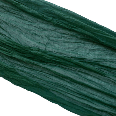 Green crinkled fabric draped elegantly on a white background.