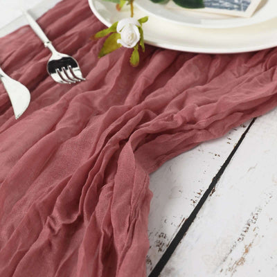Textured dusty rose table runner on a rustic wooden table setting.
